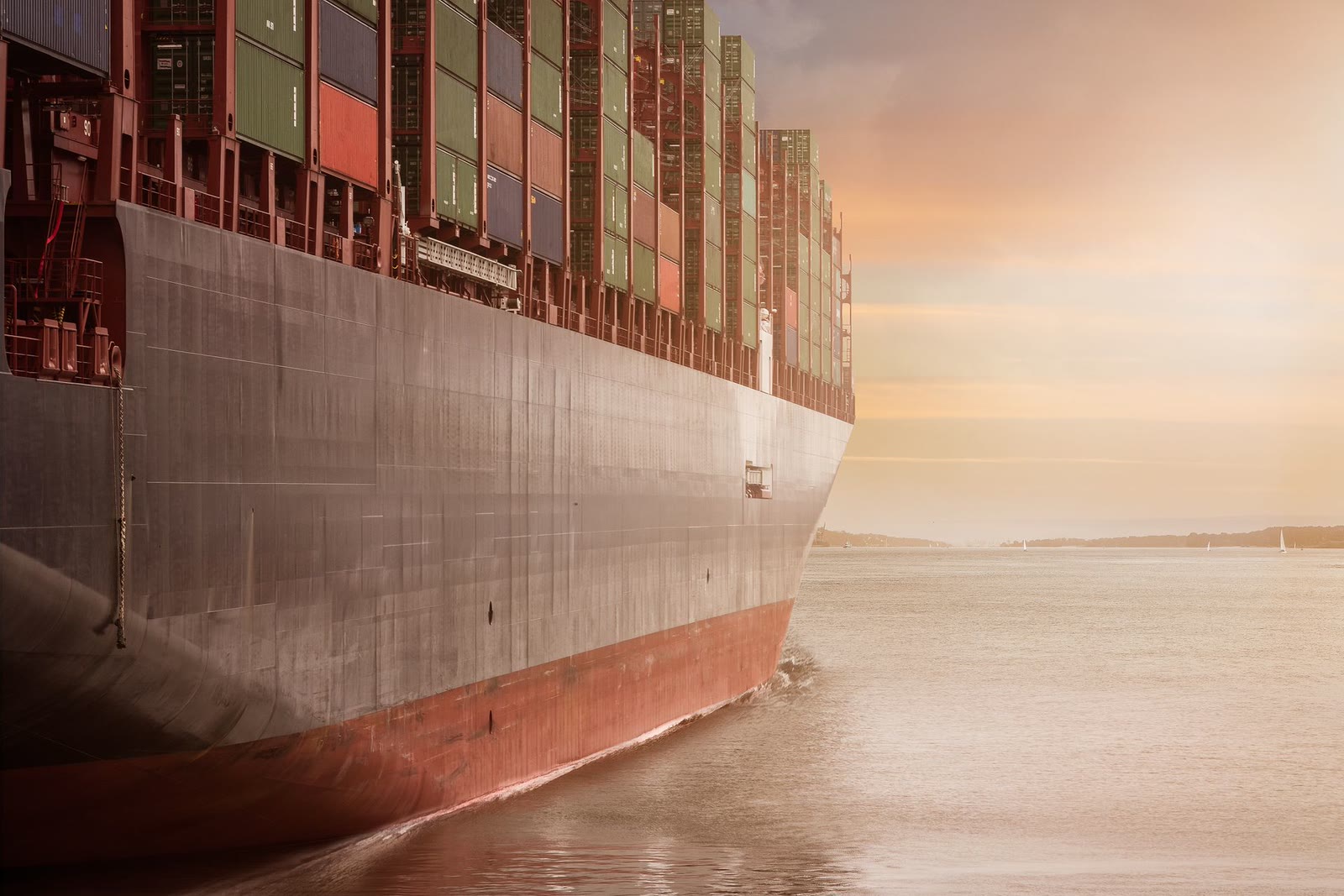 Hull of a loaded container ship at golden hour