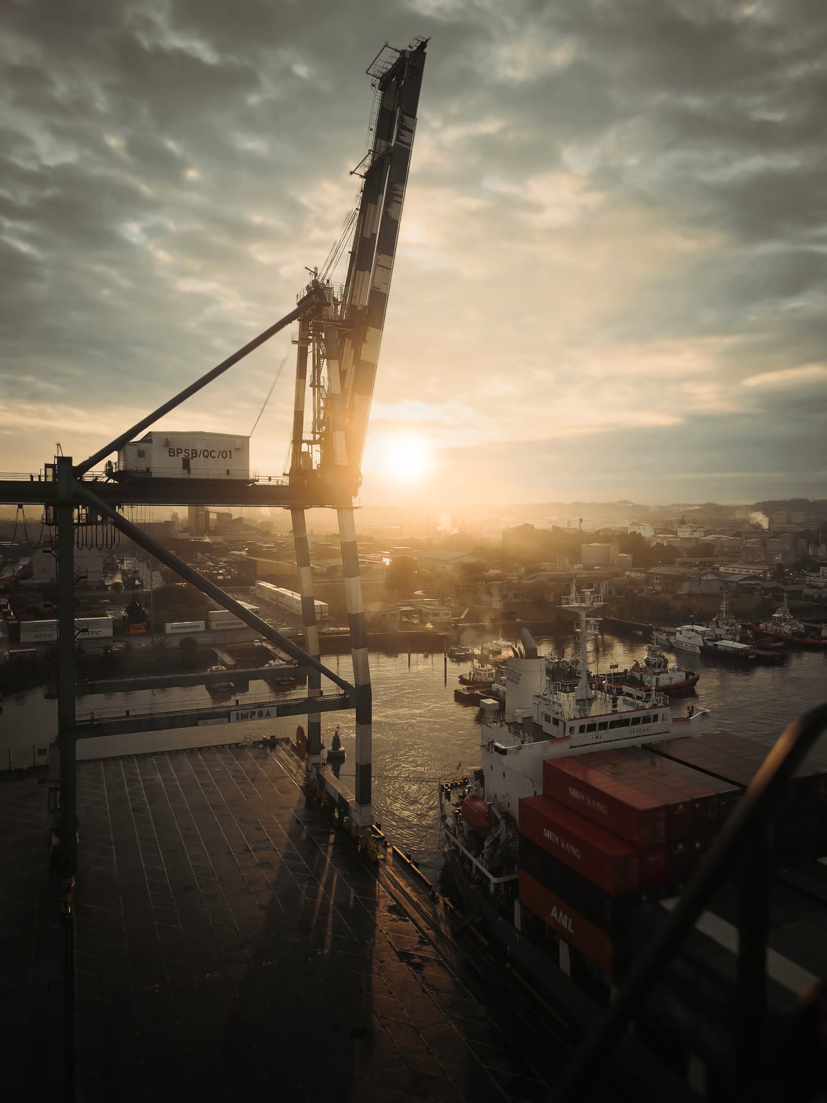 Port crane silhouetted at sunrise over the harbour