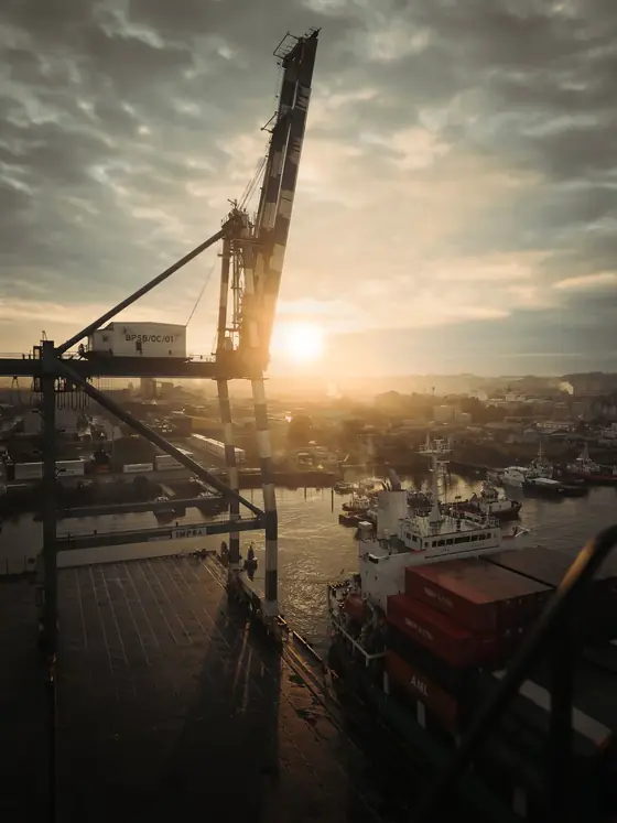 Port crane silhouetted at sunrise over the harbour